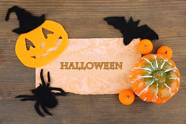 Old paper with Halloween decorations on grey wooden background — Stock Photo, Image