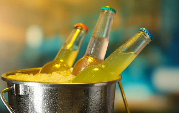 Bottled drinks in ice bucket on bright background — Stock Photo, Image