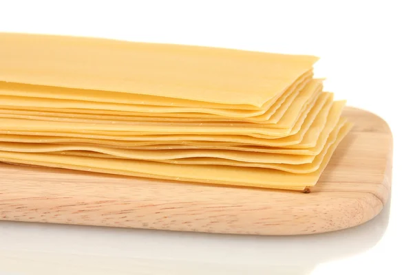 Pâtes lasagnes non cuites sur planche à découper isolées sur blanc — Photo