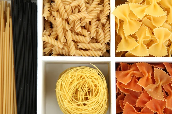 Different types of pasta in white wooden box sections close-up — Stock Photo, Image
