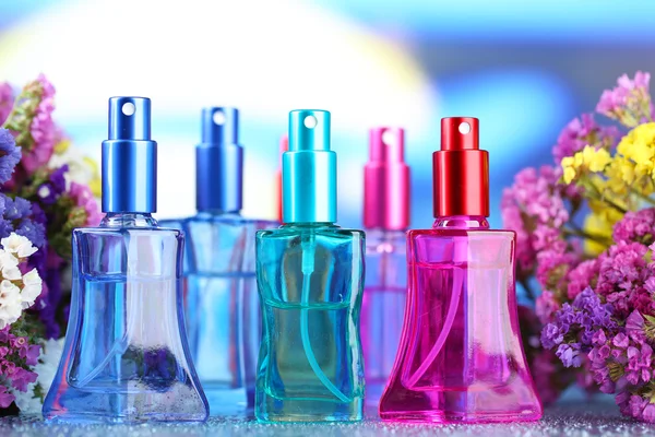 Kvinnor parfym i vackra flaskor och blommor — Stockfoto