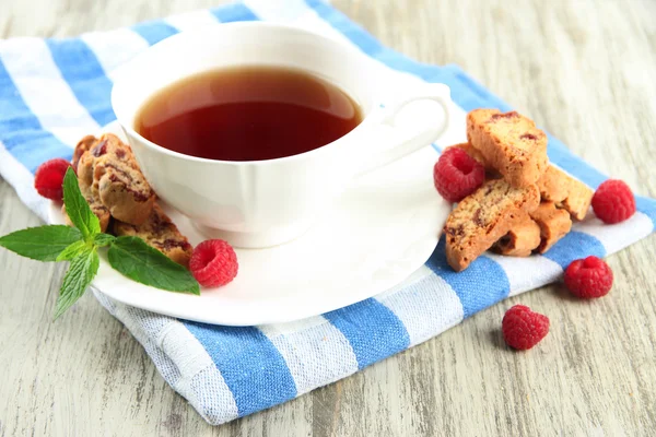 Taza de té con galletas y frambuesas en primer plano de la mesa — Foto de Stock