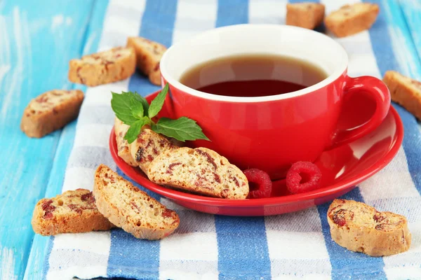 Xícara de chá com biscoitos e framboesas na mesa close-up — Fotografia de Stock