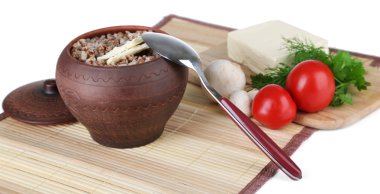 Buckwheat in pot with butter and vegetables isolated on white