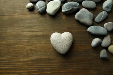 ahşap zemin üzerinde kalp şeklinde gri taş