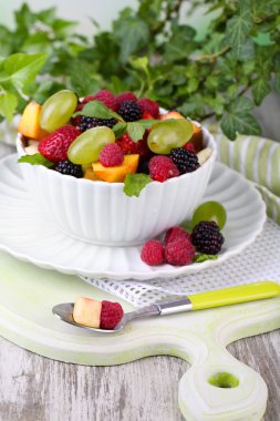 parlak zemin üzerine ahşap masa üzerinde kase meyve salatası