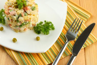 Rus salatası geleneksel ahşap arka plan üzerinde renkli peçete üzerinde olivier