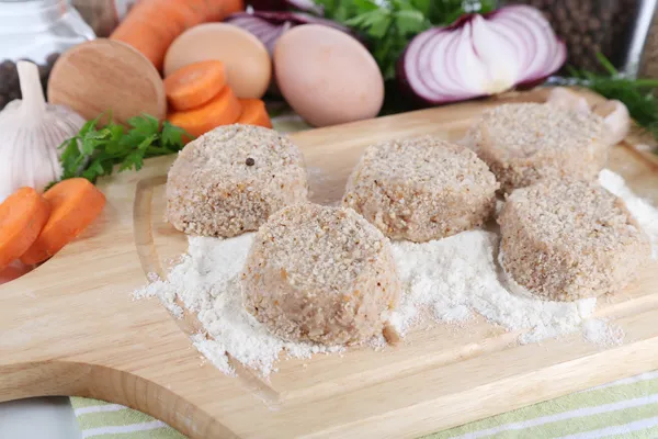 Meat patties on board on napkin — Stock Photo, Image