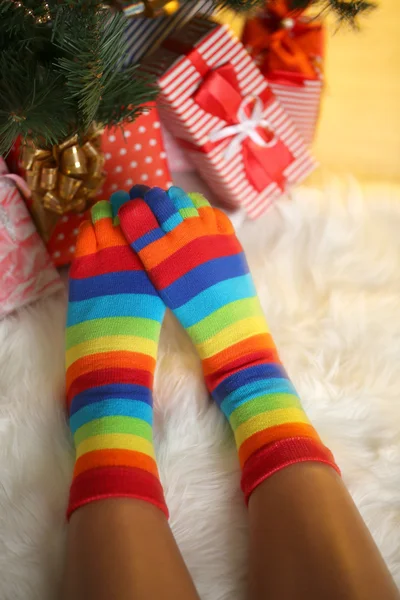 Legs in socks near Christmas tree on carped — Stock Photo, Image