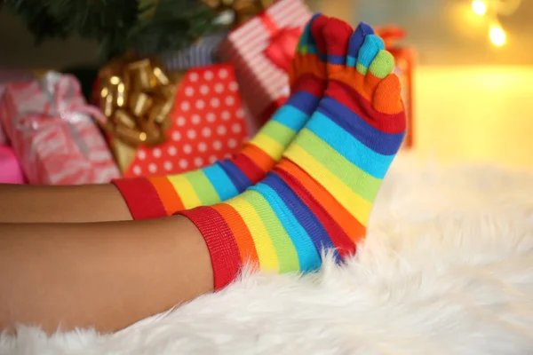 Jambes dans les chaussettes près de l'arbre de Noël sur carpé — Photo