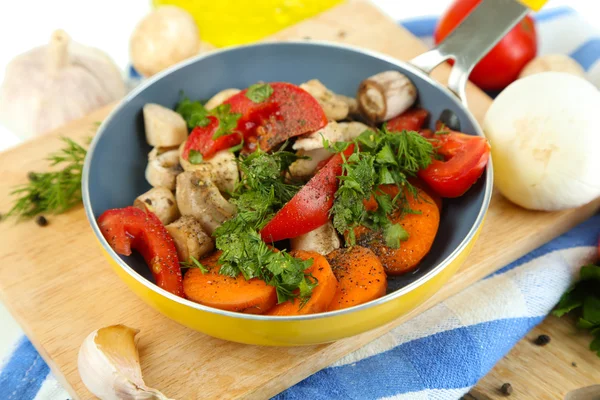 Sliced fresh vegetables in pan on wooden board isolated on white — Stock Photo, Image