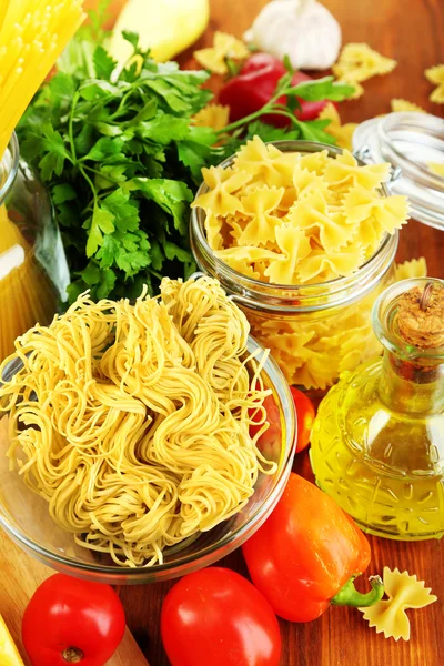 Massa com óleo, queijo e legumes em mesa de madeira close-up — Fotografia de Stock