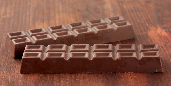 Deux délicieuses barres de chocolat sur fond en bois — Photo