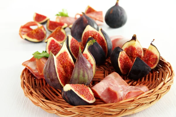 Smakelijke vijgen met ham op witte houten tafel — Stockfoto