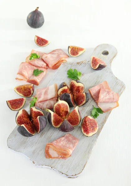 Beyaz ahşap masa üzerinde jambon ile lezzetli incir — Stok fotoğraf