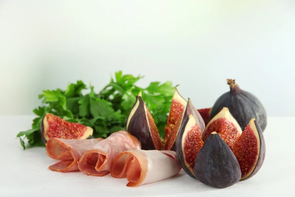 Figues savoureuses avec jambon sur la table — Photo