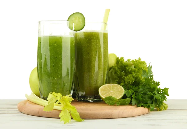 白い背景の上の木製のテーブルの上の緑の野菜ジュースのグラス — ストック写真