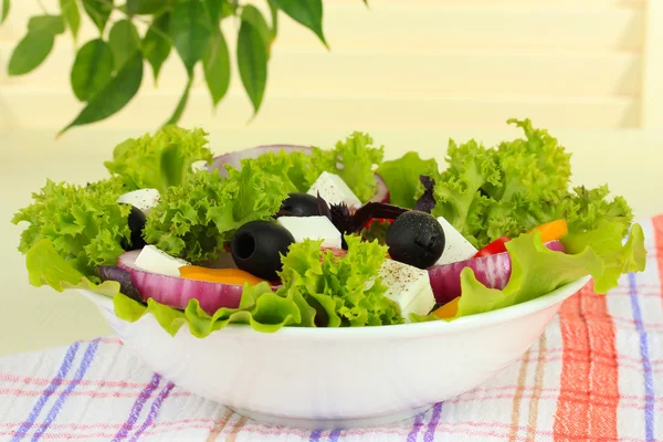 Греческий салат на тарелке на светлом фоне — стоковое фото