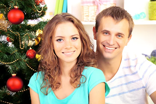 Jovem casal feliz perto da árvore de Natal em casa — Fotografia de Stock