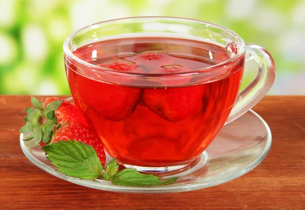 Delicioso té de fresa en la mesa sobre fondo brillante — Foto de Stock