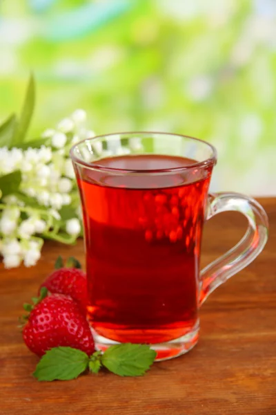 Delicioso té de fresa en la mesa sobre fondo brillante —  Fotos de Stock