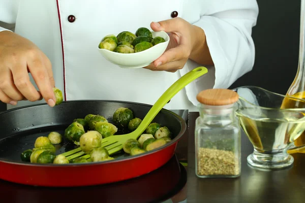 Chef prepares frresh brussels sprouts in pan on cooking surface close-up — Stock Photo, Image