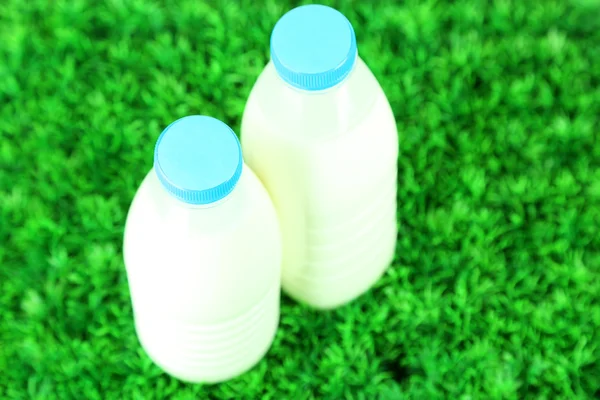 Leche en botellas sobre hierba —  Fotos de Stock