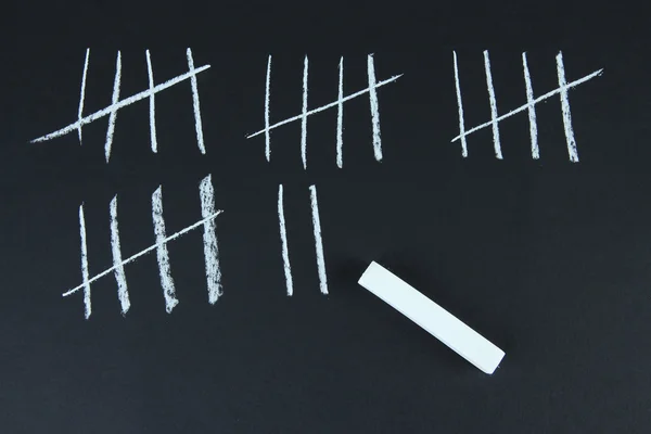 Counting days by drawing sticks isolated on black — Stock Photo, Image
