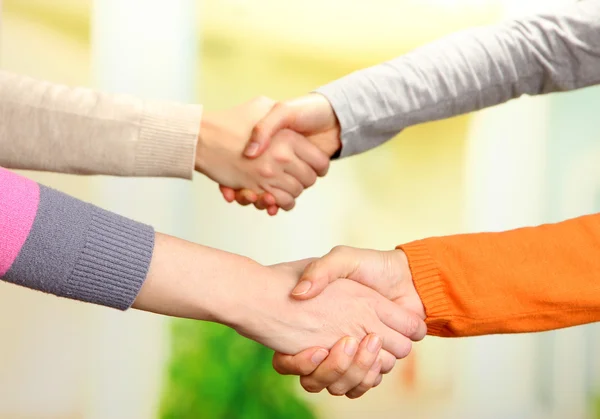 Handshakes on bright background — Stock Photo, Image