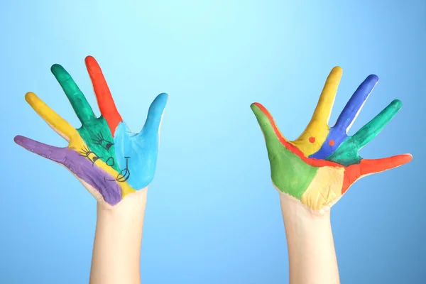 Painted hands with smile on blue background — Stock Photo, Image