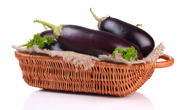 Verse aubergines in rieten mand geïsoleerd op wit — Stockfoto