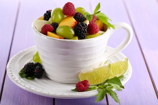 Fruktsallad i cup på träbord — Stockfoto