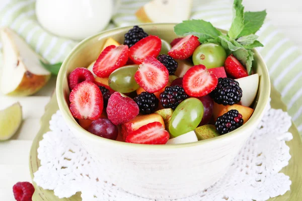 Insalata di frutta in piatti su tavolo di legno vicino a tovagliolo — Foto Stock