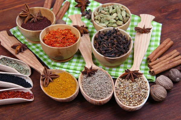 Various spices and herbs on wooden background — Stock Photo, Image