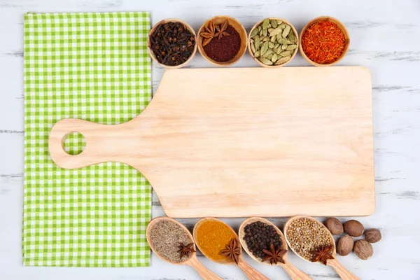 Various spices and herbs with empty wooden board — Stock Photo, Image