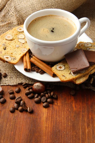 Secangkir kopi lezat dengan biskuit Italia lezat, dengan latar belakang kayu — Stok Foto