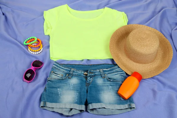 Top, shorts et articles de plage sur fond violet vif — Photo