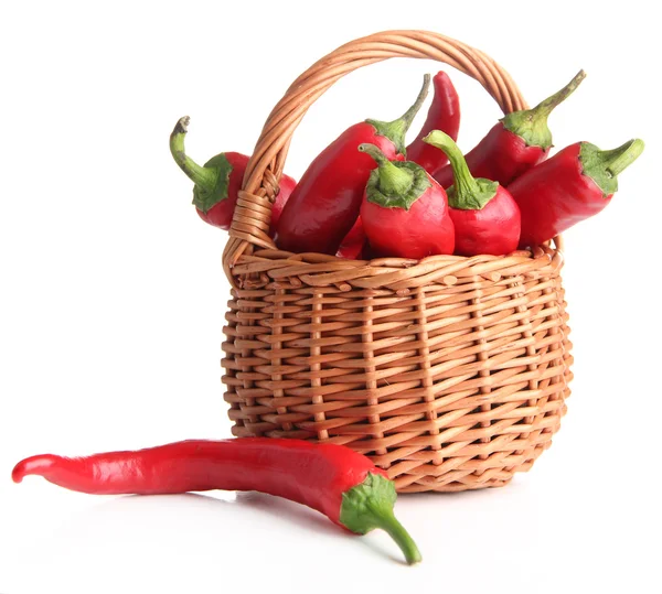 Pimientos rojos picantes en canasta de mimbre, sobre tela de saco, aislados sobre blanco — Foto de Stock