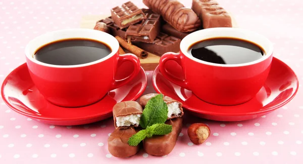 Tazze rosse di caffè forte e barrette di cioccolato da vicino — Foto Stock