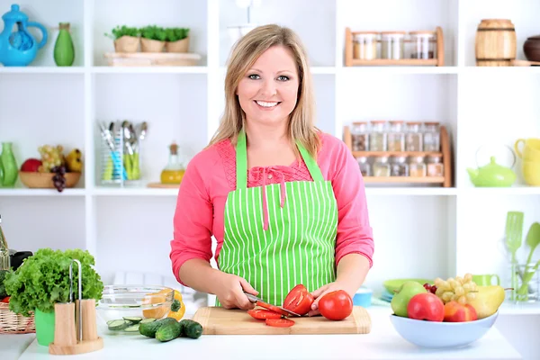 Mulher sorridente feliz na cozinha preparando salada vegetal — Fotografia de Stock