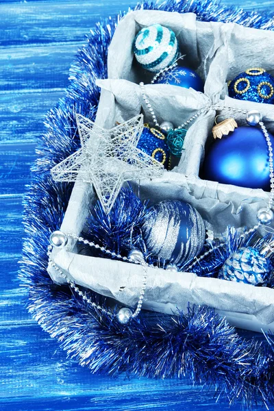Brinquedos de Natal em caixa de madeira no fundo azul — Fotografia de Stock