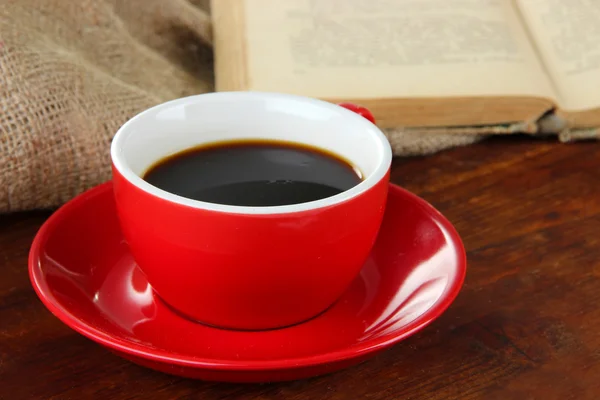 Coupe de café et livre sur table en bois sur fond de sac — Photo