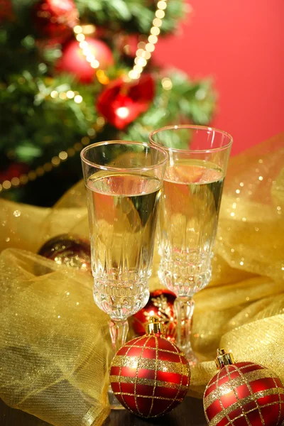 Композиция с рождественскими украшениями и двумя бокалами шампанского, на ярком фоне — стоковое фото