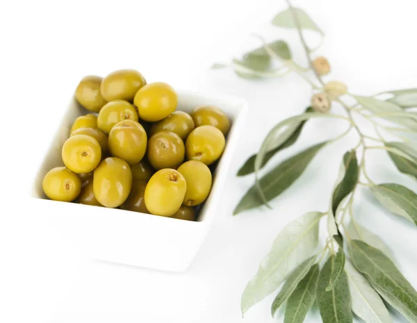 Olive in ciotola con ramo isolato su bianco — Foto Stock