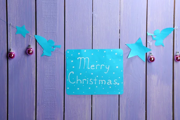 Cartello con le parole Buon Natale su sfondo tavolo di legno primo piano — Foto Stock