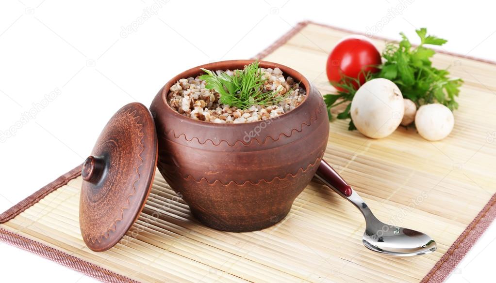 Buckwheat in pot with vegetables isolated on white