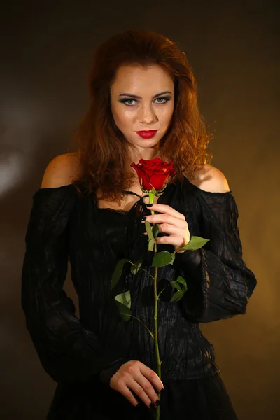 Halloween witch with rose on dark background — Stock Photo, Image