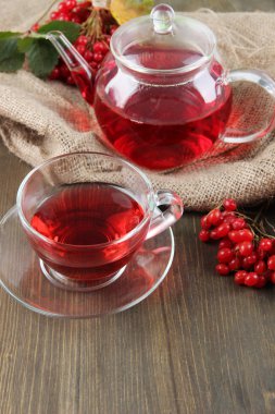 Bodegón con té de viburnum en servilleta de tela de saco, sobre fondo de madera