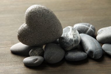 ahşap zemin üzerinde kalp şeklinde gri taş