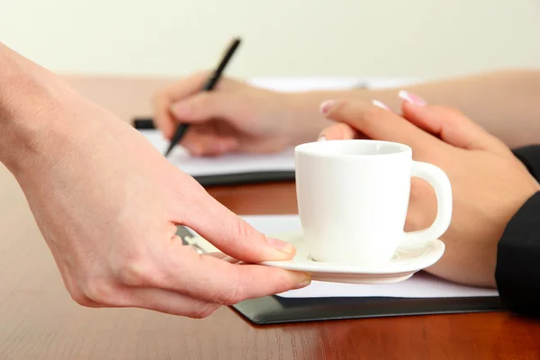 Primer plano de las manos de mujer de negocios con taza de café durante el trabajo en equipo — Foto de Stock